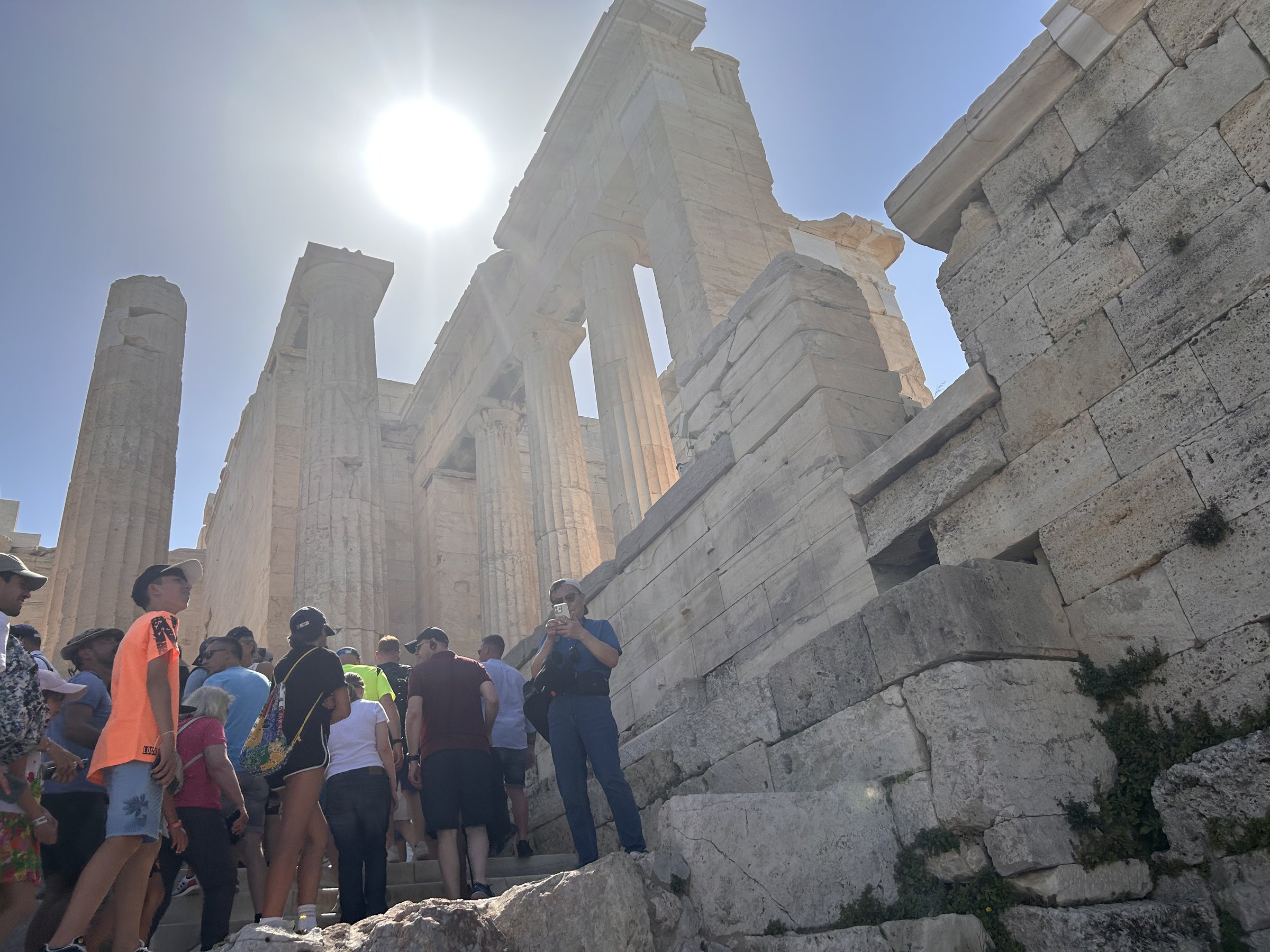 Visitors entering the Acropolis beneath bright summer sun
