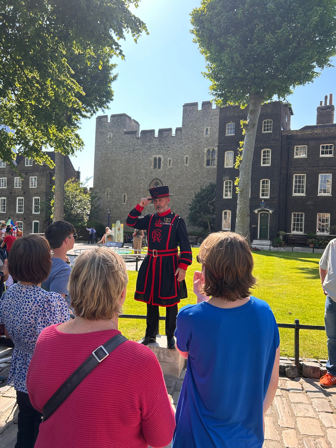 A Yeoman Warder speaking to visitors inside the Tower of London
