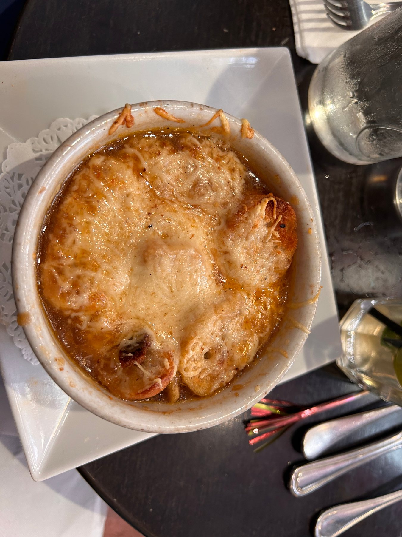A bowl of French onion soup topped with toasted bread and melted cheese